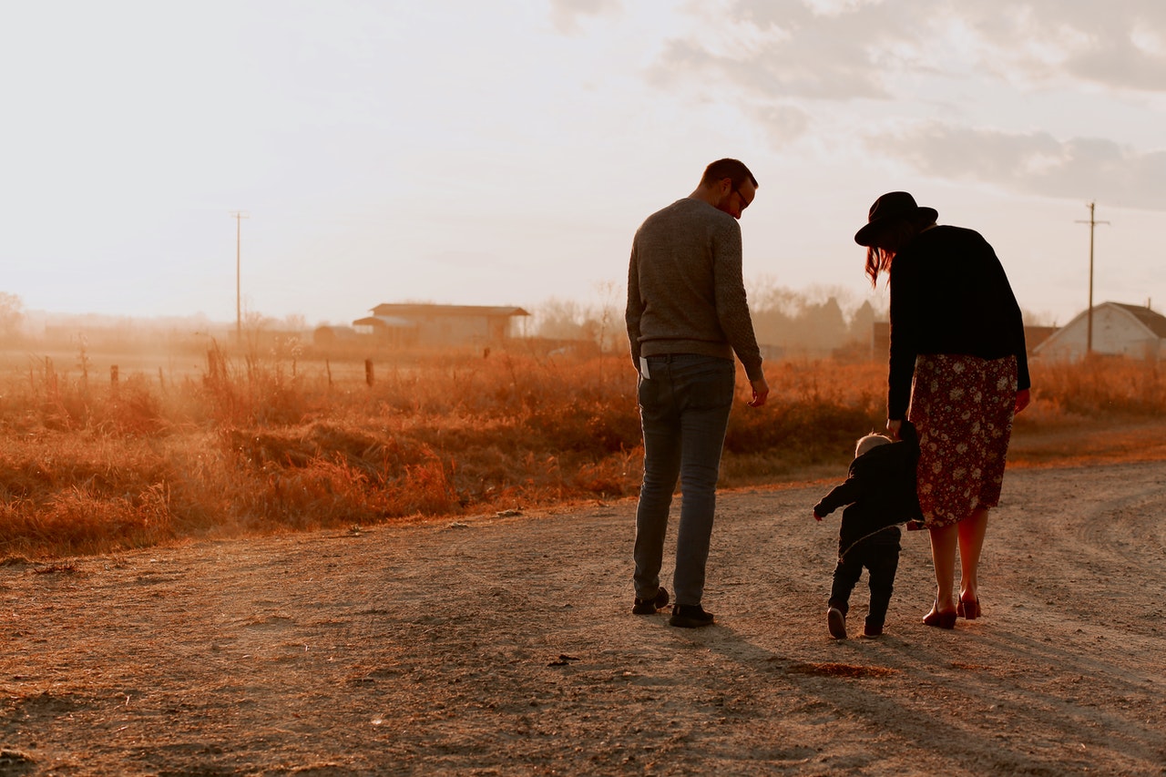 man-and-woman-walking-with-there-kid-on-dirt-road-3285036